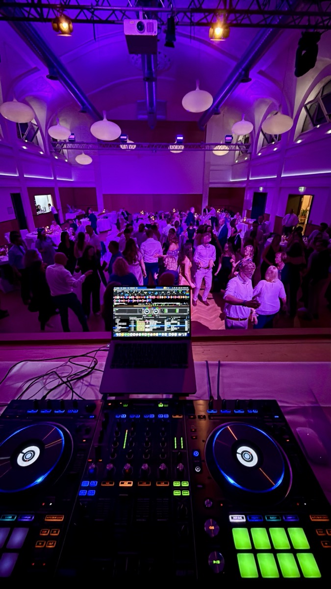 Tanzende Gäste vor dem DJ-Pult